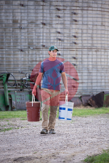 Farmer carrying grain buckets