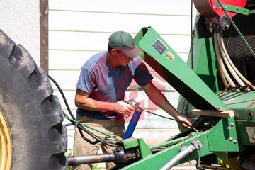 Farmer doing maintenance on a baler