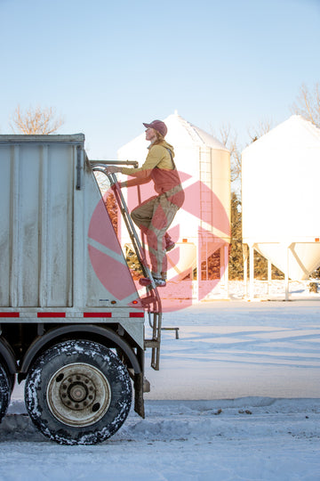 Woman climbing a grain trailer