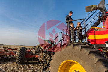 Woman and two young boys on an air seeder